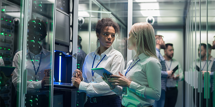 Two female professionals discussing a data tower